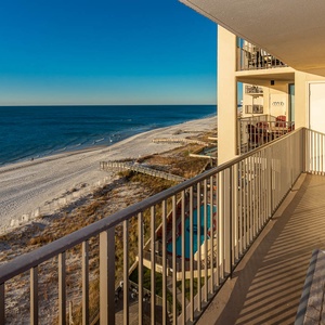 Balcony offers a serene view of the white sand beach and sparkling water, perfect for relaxation and enjoying the outdoors