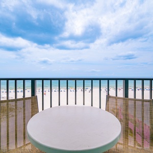 Enjoy the fresh air on the balcony with a table and chairs, overlooking the shimmering waters and beach below