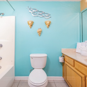 Freshen up in this vibrant guest bath featuring a spacious vanity, colorful decor, and neatly arranged towels