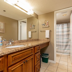 Spacious master bathroom featuring a large granite countertop, stylish decor, and a relaxing atmosphere