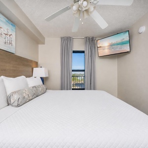 Fluffy pillows invite you to relax in the king suite for a calm movie night after a fun day at the beach