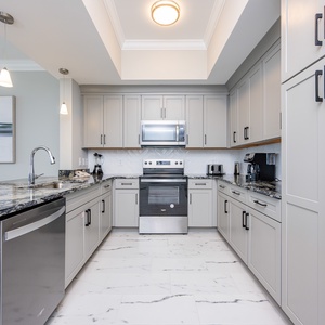 Prepare meals in this elegant kitchen featuring stunning countertops, stainless appliances, and sleek cabinetry