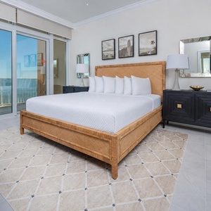 Retreat to the king master suite with cozy bedding and drift off to the sound of the waves from the balcony