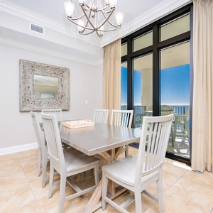 This dining area features a sleek table, beach views from the balcony, and elegant decor for a delightful meal experience