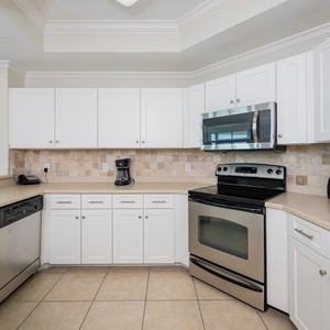 Prepare meals in this kitchen with sleek cabinetry, stainless appliances, and stylish backsplash