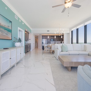 Unwind in the spacious living area featuring a large sectional sofa with queen sleeper and panoramic beachfront scenes
