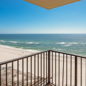 The balcony offers a panoramic view of the sparkling water and white sand beach, inviting relaxation and enjoyment