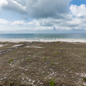 Expansive view of the beach with colorful umbrellas dotting the shoreline, inviting relaxation and seaside enjoyment