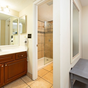 The master bathroom features a stylish vanity with wooden cabinetry, a walk-in shower, and ample natural light