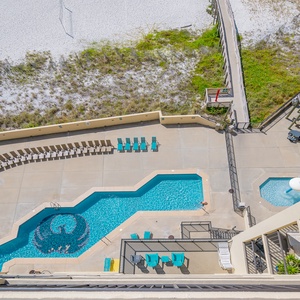 Enjoy a refreshing poolside retreat with lounge chairs and a view of the serene beach just steps away