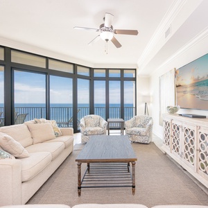 Bright and airy living room featuring plush seating, a large TV, and vibrant artwork for a cozy beachside retreat