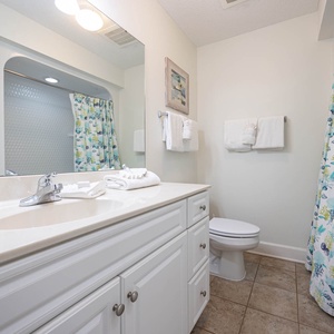 Refresh in this guest bathroom featuring a spacious vanity, soft towels, and a colorful shower curtain for a cheerful touch