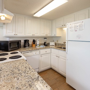 This kitchen features white appliances and ample counter space for preparing meals during your stay