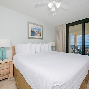Relax in the master bedroom with a king bed, coastal decor, and direct access to the beach balcony