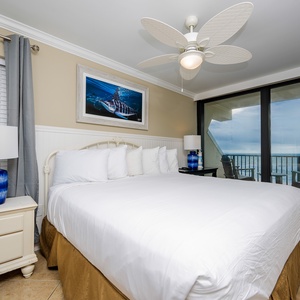 This bedroom features a king bed, a TV, and a stunning beachfront view through large sliding glass doors