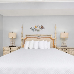 Master suite featuring a king bed, elegant decor, and warm bedside lamps for a cozy retreat