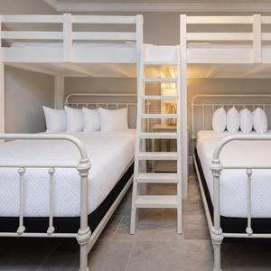 Relax in this fun bunk room featuring a loft bunks design with twins over queens and stylish lighting