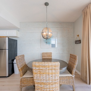 A basket chandelier glows above your dining area with a sliding glass door to your balcony nearby