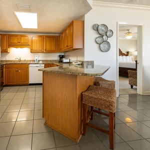 Warm tones highlight the kitchen where you prepare meals and converse beside the breakfast bar stools