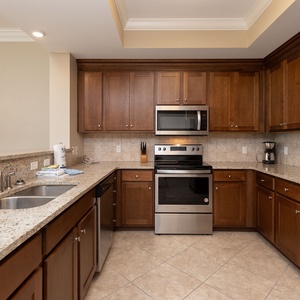 Prepare meals in this kitchen with elegant cabinetry, stainless appliances, and spacious countertops