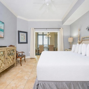 Cheerful master bedroom featuring a plush king bed and stunning views through glass doors leading to a cozy dining area