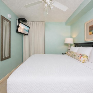 Fluffy pillows invite you to relax in the king suite for a calm movie night after a fun day at the beach