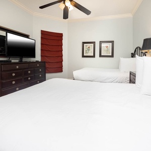 Comfortable guest bedroom featuring two cozy double beds, a TV for entertainment, and charming decor