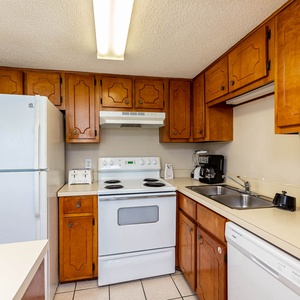 This kitchen features wooden cabinetry, essential appliances, and a welcoming atmosphere for preparing meals