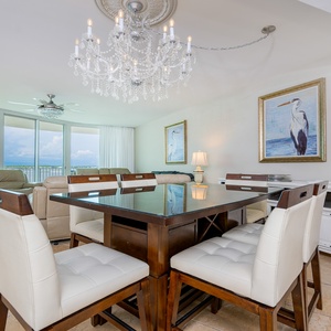 Bright dining area featuring a chic table, elegant chandelier, and stunning views through large windows
