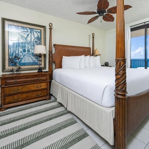 Unwind in the spacious master bedroom featuring a four-poster king bed, elegant decor, and beachfront balcony access