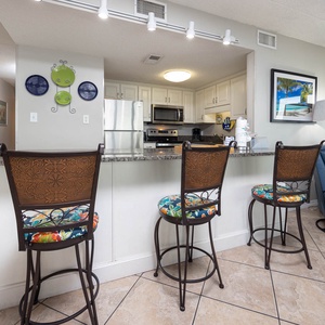 This inviting kitchen features stylish bar seating, stainless appliances, and a vibrant view of the surrounding area