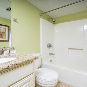 Bright guest bathroom featuring a granite countertop, modern fixtures, and a tub/shower combo for a refreshing experience