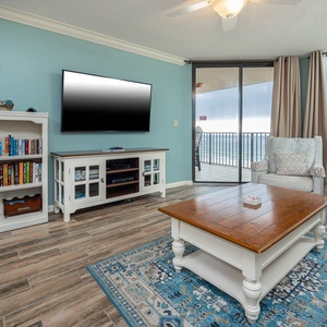Unwind in the inviting living area, featuring plush seating, a large TV, and stunning beach views