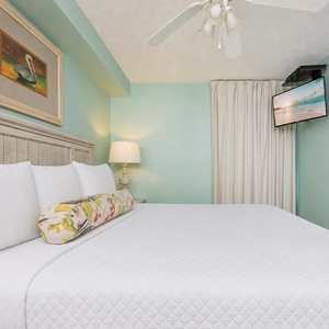 Fluffy pillows invite you to relax in the king suite for a calm movie night after a fun day at the beach