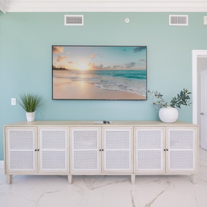 Enjoy the serene living space with a stylish cabinet and a large TV for streaming your favorite shows