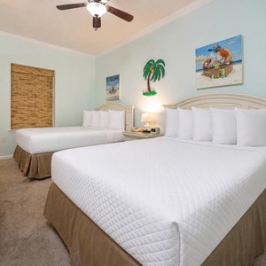 This guest bedroom features two double beds with soft linens, tropical artwork, and a cozy ambiance for a relaxing stay
