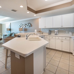 Prepare meals easily in this spacious kitchen with ample counter space and a view of the beach