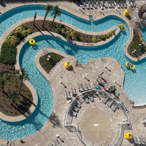 Float on a yellow tube through the lazy river, drift past palms and near the winding waterslide