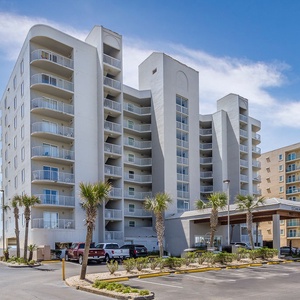 Experience a beachfront vacation at Ocean House in Gulf Shores with palm trees and easy access to the sandy shore