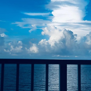 Breathe in the warm gulf air from your balcony as towering clouds mirror on the water