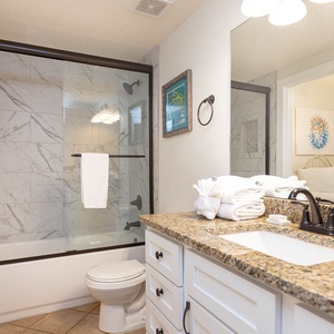 Refresh in the elegant guest bathroom featuring a spacious vanity, stylish fixtures, and a glass-enclosed shower