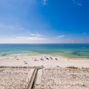 Bright blue skies stretch overhead as you watch colorful parasails glide far above the sparkling coast