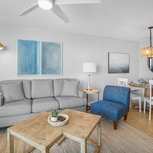 The living area features a gray sofa with queen sleeper, blue accent chair, wooden coffee table