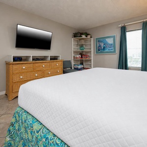 Cozy king master suite with a large TV and a lovely view through the window