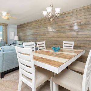Savor a family meal or enjoy a fun game night in this inviting dining space adorned with a shiplap accent wall and bech views