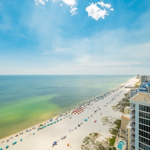Gaze at the seemingly endless coastline, with colorful umbrellas dotting the shore and glistening gulf water
