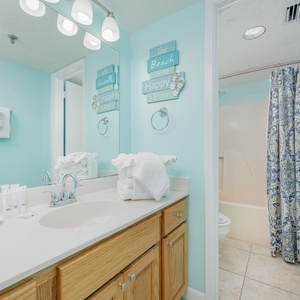 Towels folded like seashells welcome you to refresh in this calm master bath with coastal decor accents