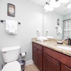 Experience the guest bathroom with a spacious granite countertop, stylish fixtures, and fresh towels