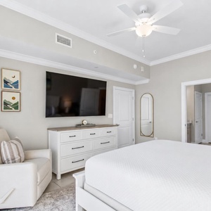 Elegant master bedroom featuring a king bed, a large TV, and beachfront balcony access