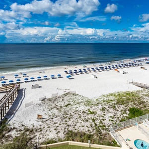 Enjoy the breathtaking views of the sandy beach and vibrant umbrellas from your private balcony, perfect for relaxation